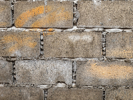 Bricks and blocks are laid together and connected by cement. It is a large wall with rough surface because the wall is not plastered to be smooth. old because of the sun and the rainの写真素材