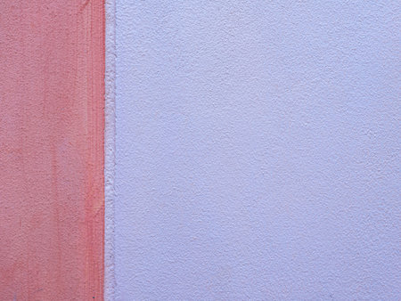 Rough cement wall surface painted in two tone pastel orange.の写真素材