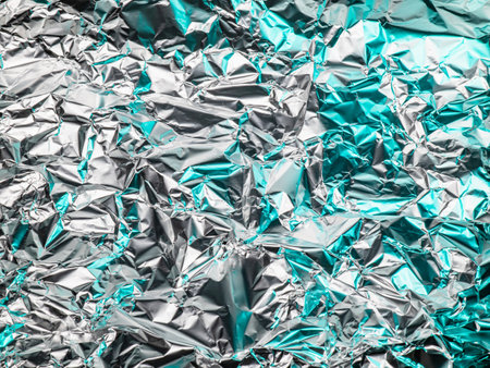 The surface of the foil is wrinkled. There was a green light reflecting light and shadow. and saw silverの写真素材