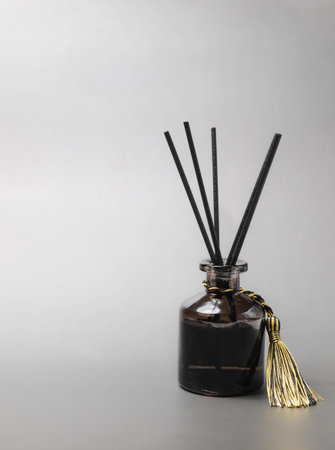 long black fragrant sticks one by one In a luxury opaque glass bottle with essential oils to spread the fragrance gray background There is a text area.の写真素材