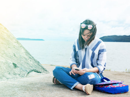 woman sit with her suitcase luggage on beautiful  sea view on sunny day joy nature, sea, back viewの写真素材
