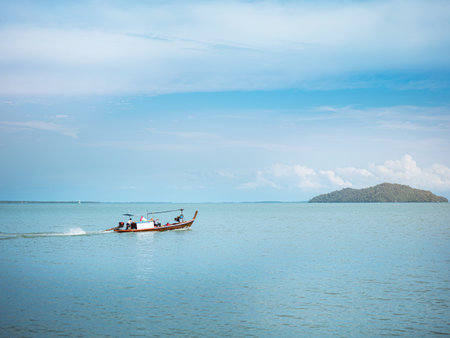Fishing boat on the water. Port coastline in the background with a small island ,sea and sky with...