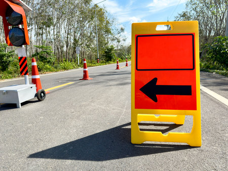 Floor-mounted folding signs warning the road to follow the black arrows for safety on the road.の写真素材