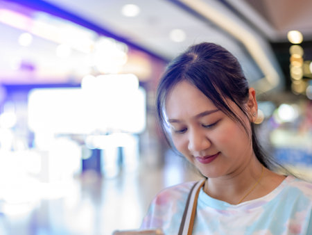 Young Asian woman browsing something mall-themed. Head shot, copy space included.の写真素材