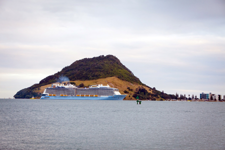 TAURANGA, NEW ZEALAND - DECEMBER 26, 2016: The mighty Ovation of the Seas Cruise Ship by Royal Caribbean International enters Tauranga Harbour for the very first time. Mount Maunganui in the background.のeditorial素材