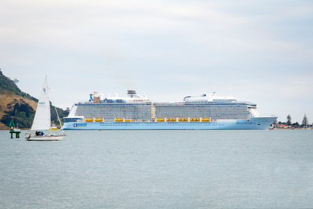 TAURANGA, NEW ZEALAND - DECEMBER 26, 2016: The mighty Ovation of the Seas Cruise Ship by Royal Caribbean International enters Tauranga Harbour for the very first time. Mount Maunganui in the background.のeditorial素材
