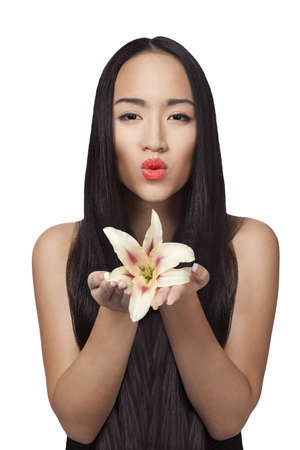 chinese girl is holding lily in her hands isolated on whiteの写真素材