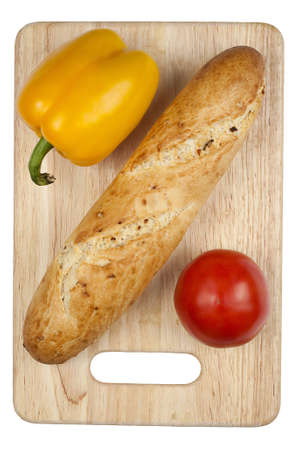 uncutted bread with vegetables on the kitchen board  isolated on whiteの写真素材