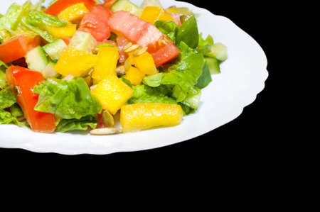 Salad with tomato, pepper, pumpkin seeds on the white  plate isolatedの写真素材