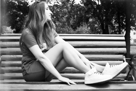 Beautiful model sits on a bench in the Park. Summer. black and white photographyの写真素材