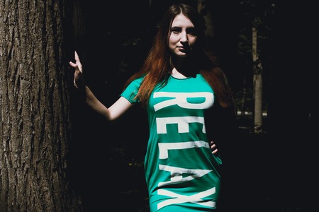 The girl and the big tree in the forest. Summer