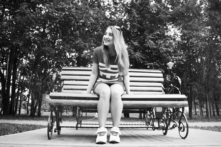 Beautiful model sits on a bench in the Park. Summer. black and white photographyの写真素材