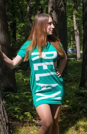The girl and the big tree in the forest. Summerの写真素材