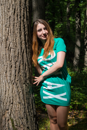 The girl and the big tree in the forest. Summerの写真素材