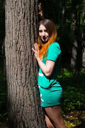 The girl and the big tree in the forest. Summerの写真素材