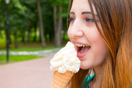 Girl in summer day eating cool ice cream.の写真素材