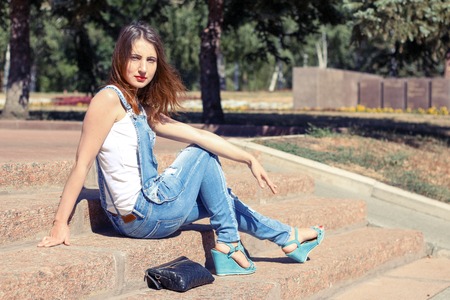 Girl sitting on the stairs in hot summer dayの写真素材