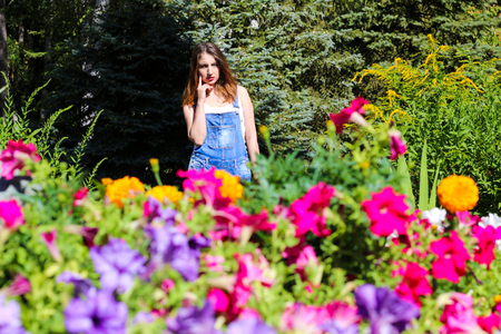 Young woman posing on the background, the foreground flowersの写真素材