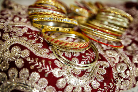Gold Indian womens bracelets lie on a sariの写真素材