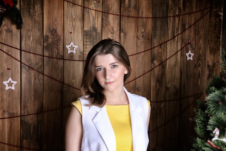 Portrait of young woman on a wooden wall background. Christmas styleの写真素材