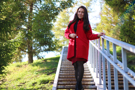 beautiful asian woman in red coat standing on stairsの写真素材