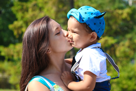 Happy young mother kisses her little sonの写真素材