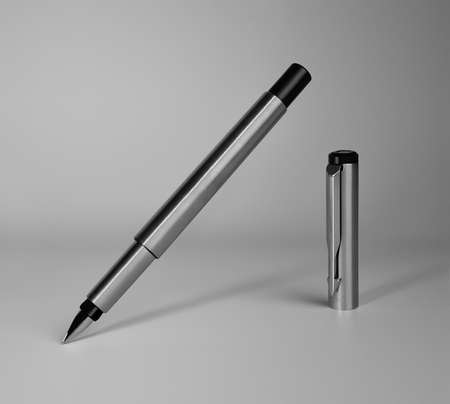 Premium class metal pen tilting and writing message near cap on gray backgroundの写真素材