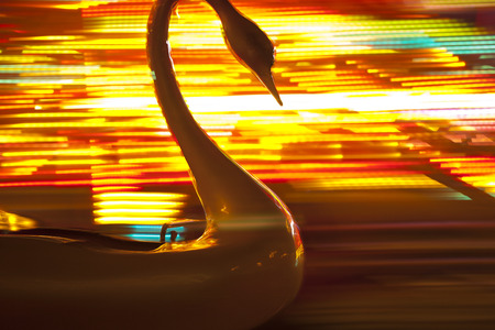 Plastic swan on the merry go round with blurred colored background. Photo taken 5. november 2014の写真素材