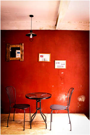 Table by the red wall in a cafeの写真素材