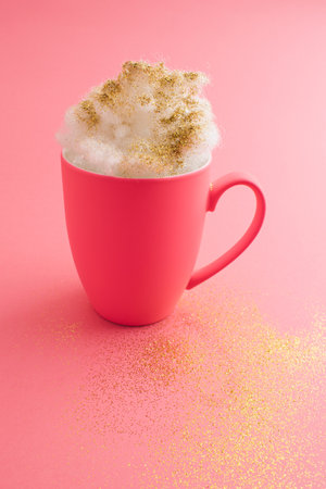 Pink cup with a gold drink. Romantic background. Pastel colors.の写真素材