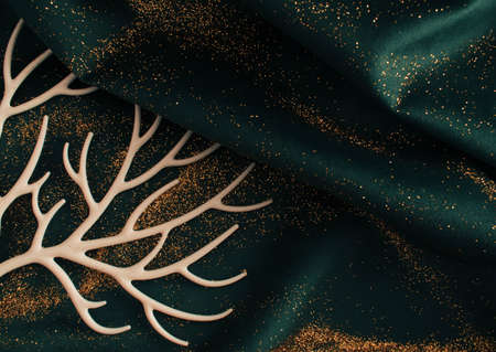 Gold glitter in a cup on green fabric. Flat lay