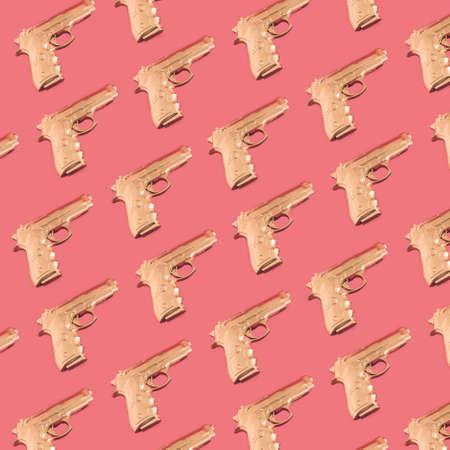 Pattern with gold gun on pink backgroundの写真素材