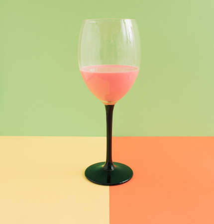 Cold and fresh pink drink for summer party on green, pink and blue backgroundの写真素材