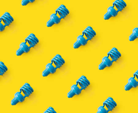 Blue light bulb pattern on yellow background. Colorful and creative concept.の写真素材