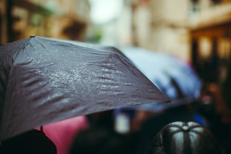 Black umbrella with drops, close up, on the street, soft-focus