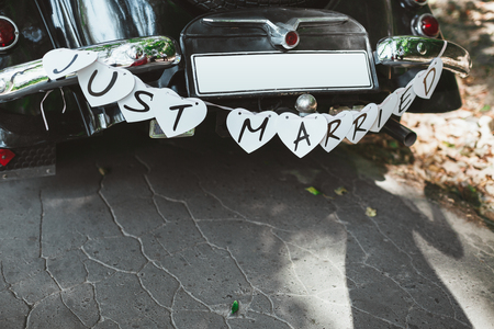 Wedding ceremony. Wedding car decorated with hearts and inscription Just married. Outdoor, day, no peopleの写真素材