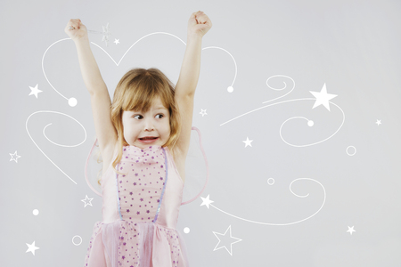 Cheerful little girl with magic stickの写真素材