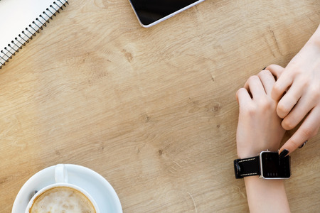 Cup of coffee, notebook, watch on tableの写真素材