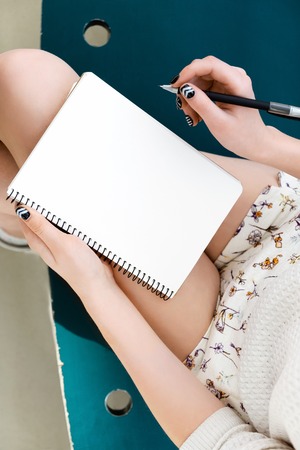 Girls legs, writing in notebookの写真素材