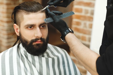 Man with dark hair doing a haircutの写真素材