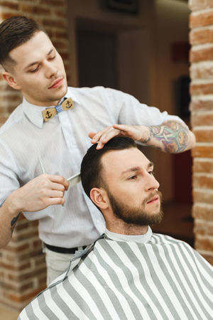 Man with dark hair doing a haircutの写真素材