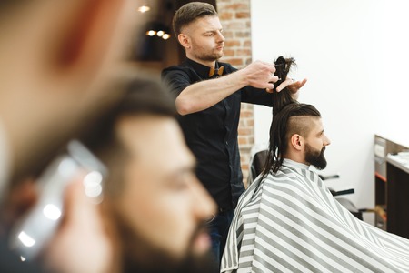 Man with dark hair doing a haircutの写真素材