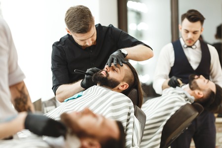 Barbers making a beard form for clientsの写真素材
