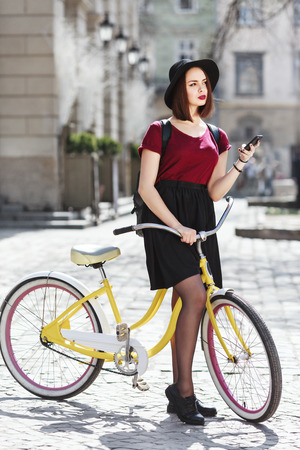 Beautiful girl on bicycle with phoneの写真素材