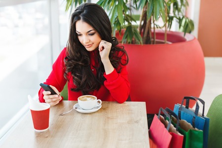 Nice girl in cafe at shopping mall with coffeeの写真素材