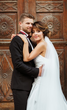 Bridegroom and bride standing near wooden doorの写真素材