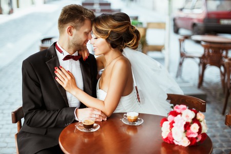 Bride and bridegroom sitting in cafeの写真素材