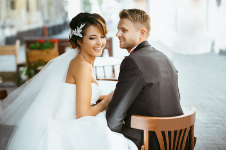 Bride and bridegroom sitting on chairsの写真素材