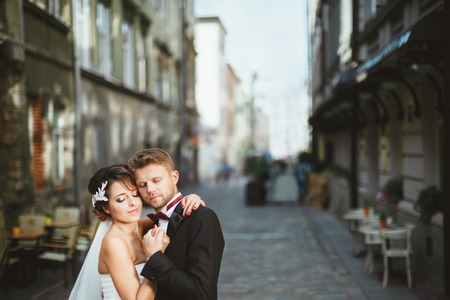 Bride and bridegroom embracing at streetの写真素材
