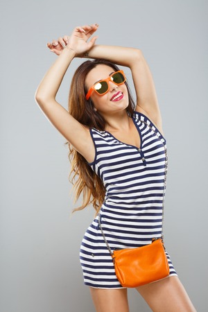 Pretty fashion model posing at gray backgroundの写真素材